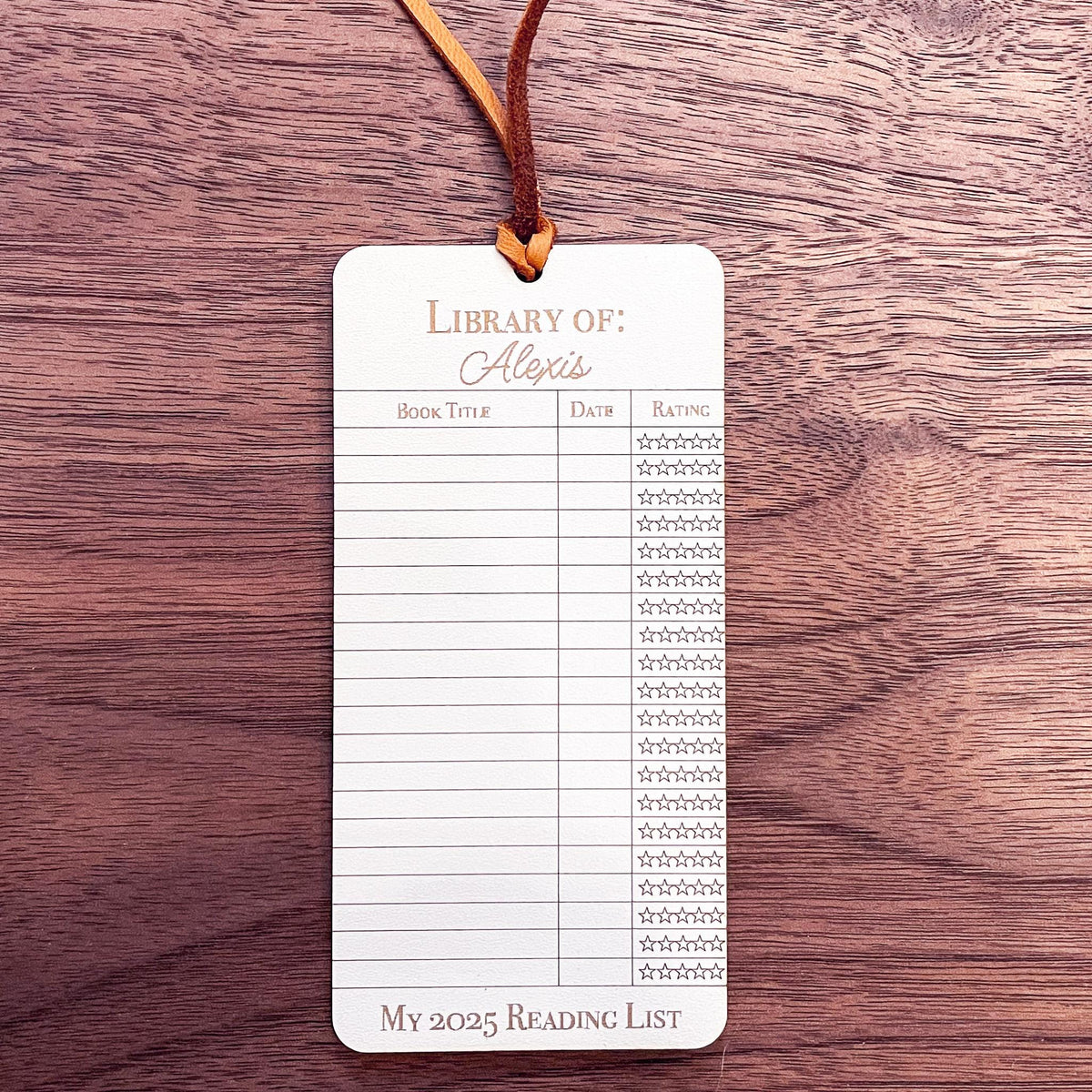 This bookmark features a library checkout card design, complete with a suede string detail for a stylish touch.