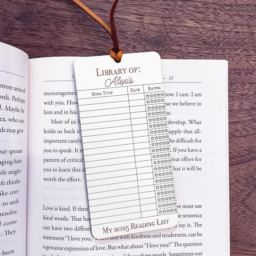 This bookmark features a library checkout card design, complete with a suede string detail for a stylish touch. (book not included)
