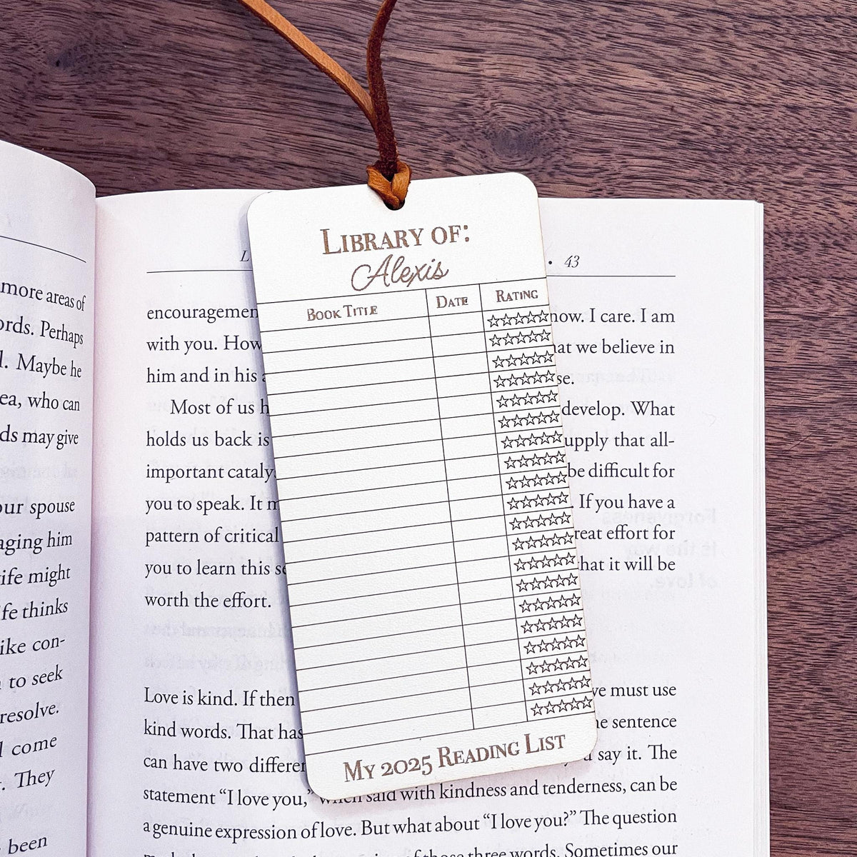 This bookmark features a library checkout card design, complete with a suede string detail for a stylish touch. (book not included)