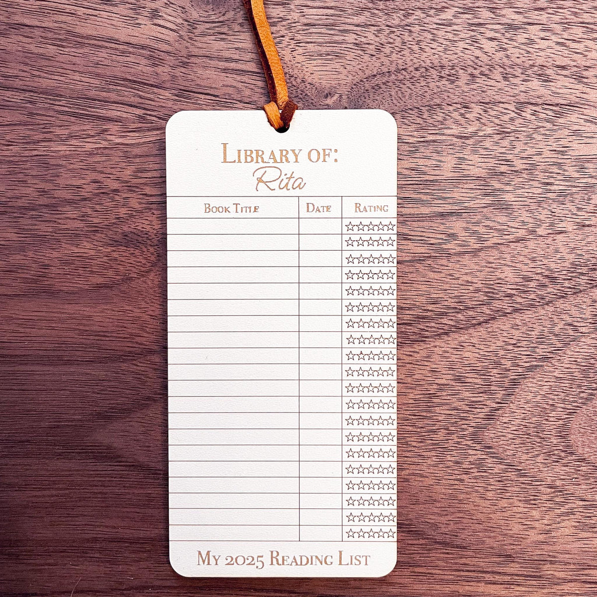 This bookmark features a library checkout card design, complete with a suede string detail for a stylish touch.