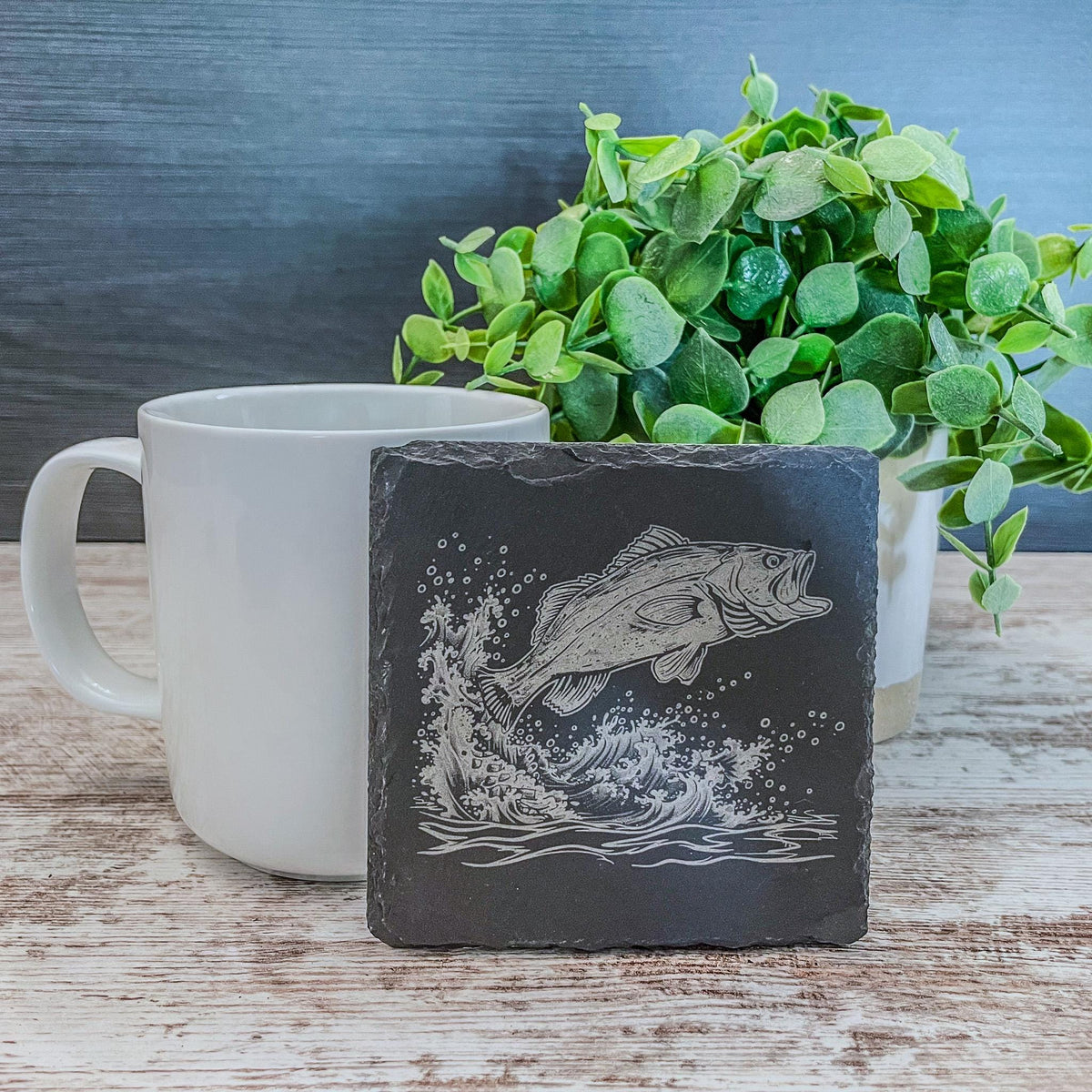 Slate coasters with bass fish laser engraved on them in 4 different scenes.