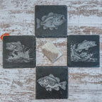 Slate coasters with bass fish laser engraved on them in 4 different scenes.