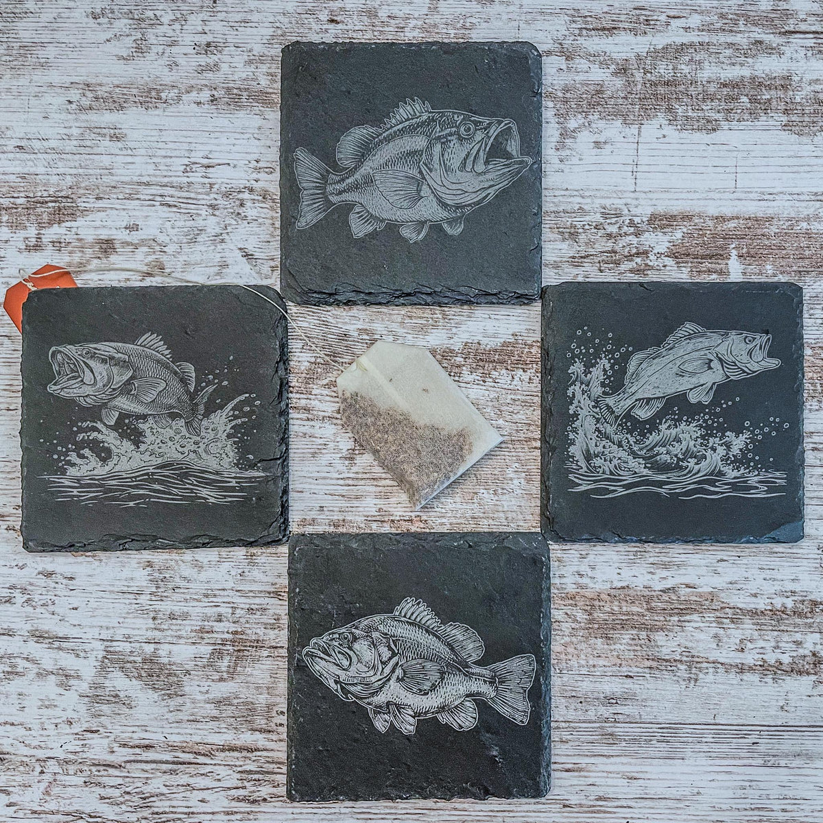 Slate coasters with bass fish laser engraved on them in 4 different scenes.