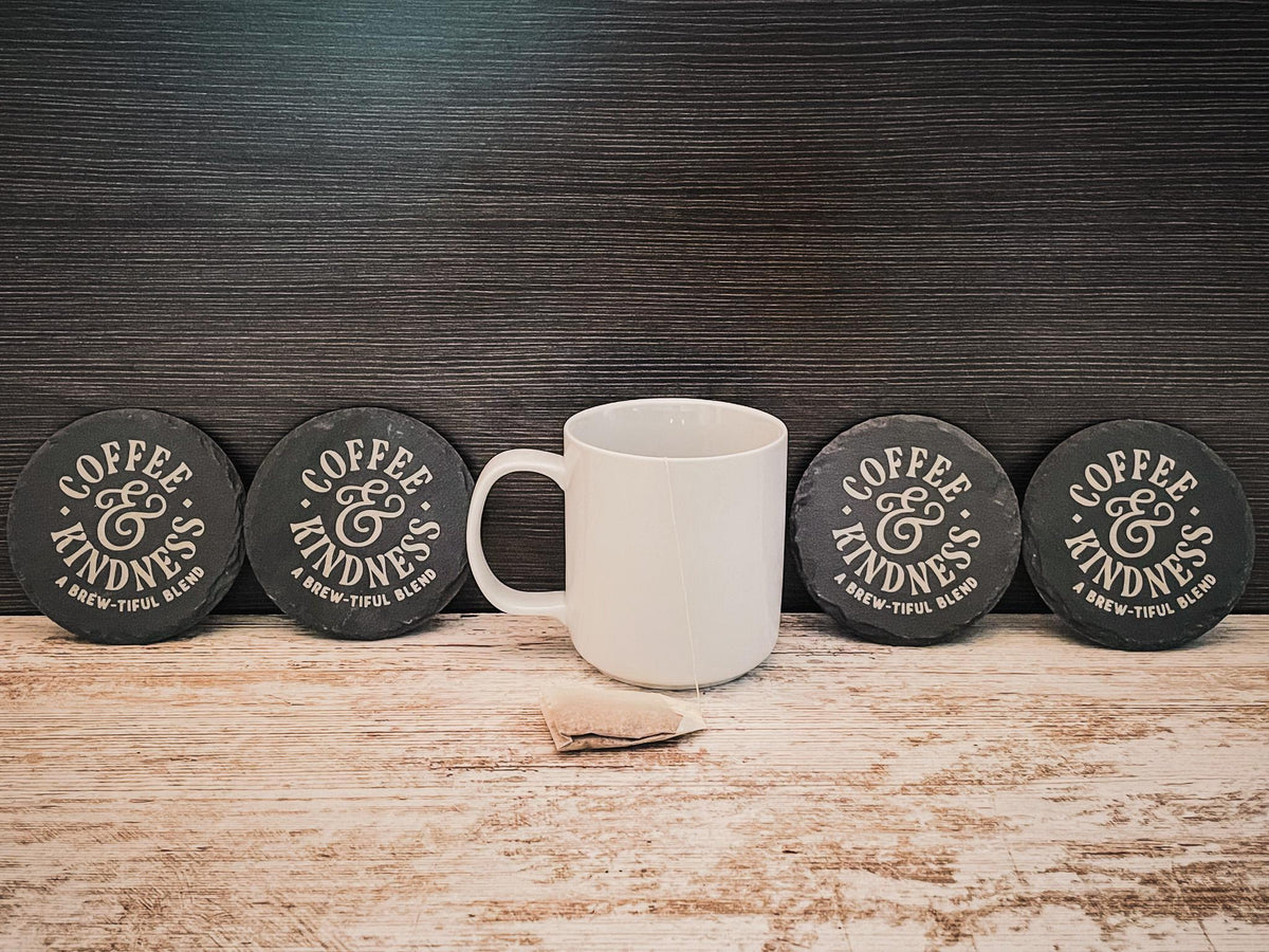 Coffee and Kindness a brew-tiful blend engraved on round slate coasters, set of 4