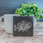 Slate coasters with bass fish laser engraved on them in 4 different scenes.