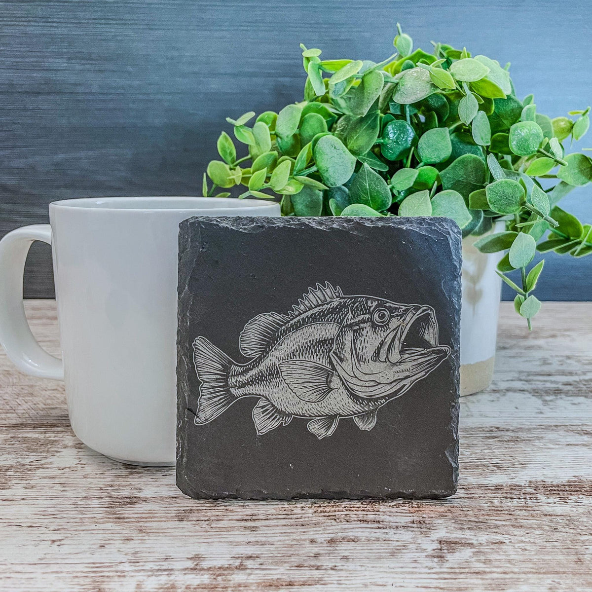 Slate coasters with bass fish laser engraved on them in 4 different scenes.