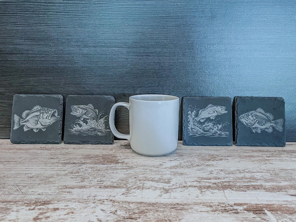 Slate coasters with bass fish laser engraved on them in 4 different scenes.