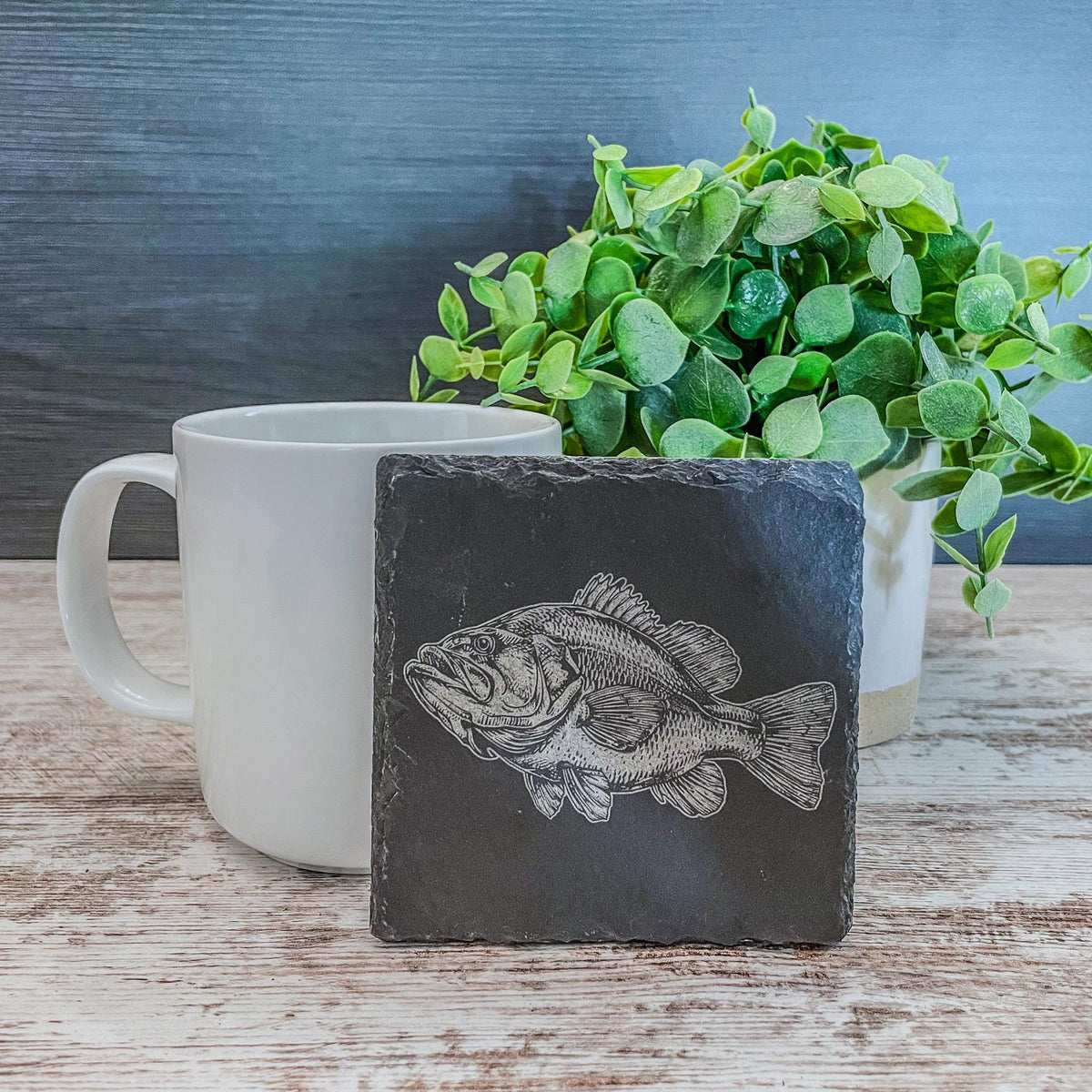 Slate coasters with bass fish laser engraved on them in 4 different scenes.