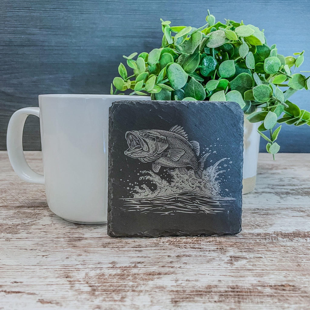 Slate coasters with bass fish laser engraved on them in 4 different scenes.