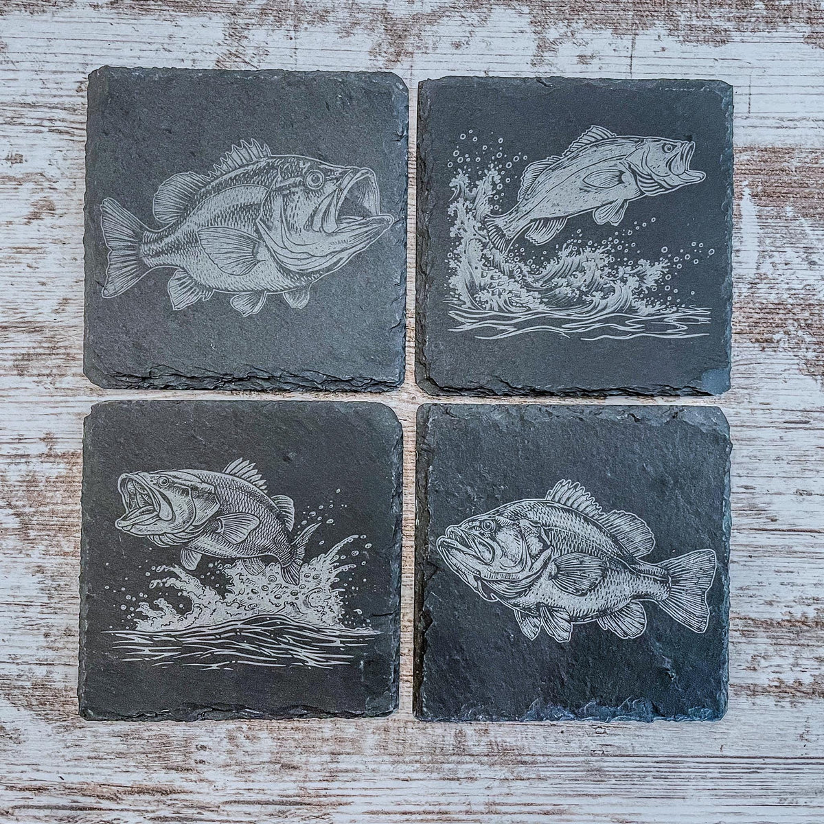 Slate coasters with bass fish laser engraved on them in 4 different scenes.